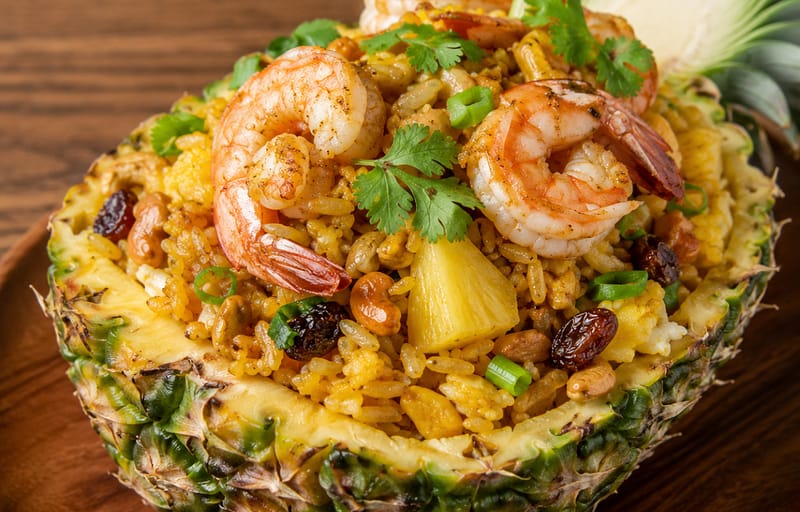 Thai pineapple fried rice NYC served in a pineapple bowl with shrimp and cashews