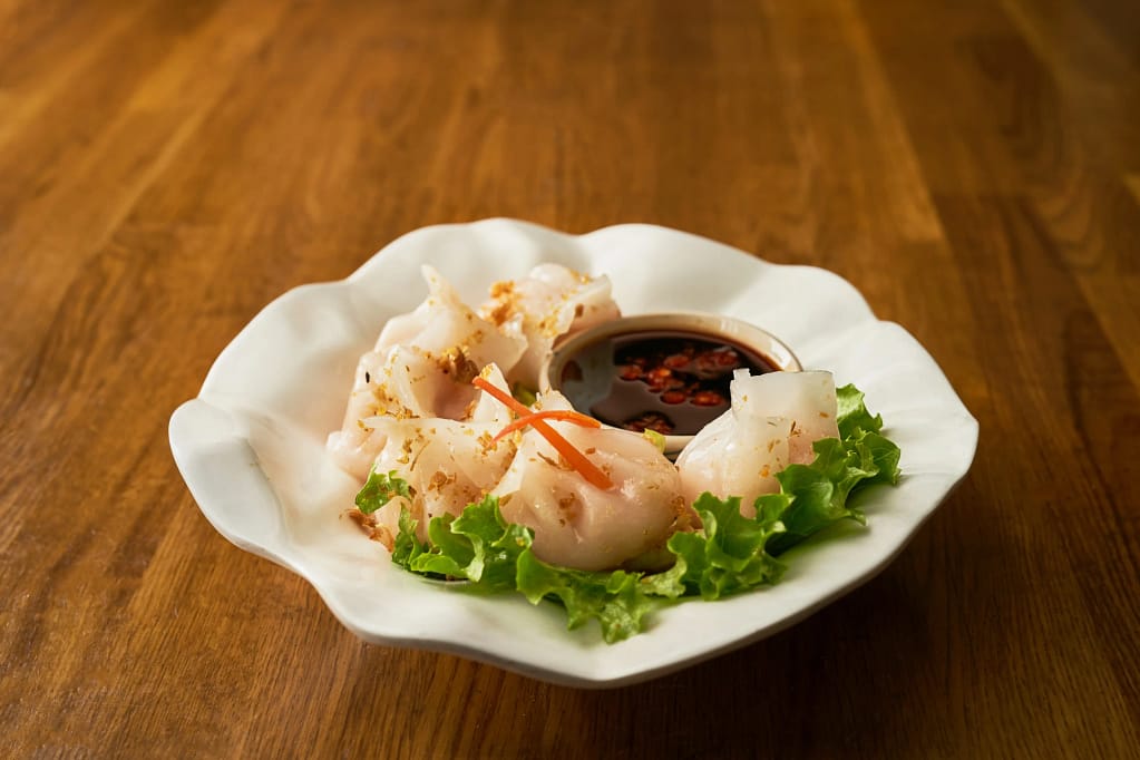 Thai shrimp dumplings with crispy garlic herbs and chili dipping sauce in NYC