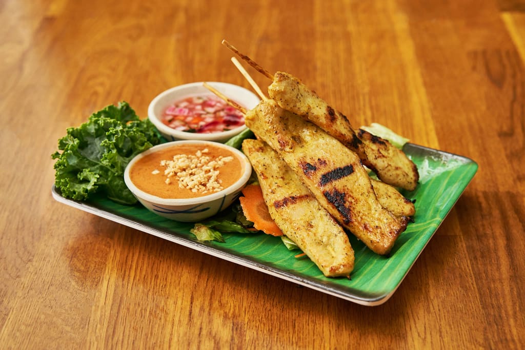 Thai chicken satay skewers with peanut sauce served as Thai street food in NYC