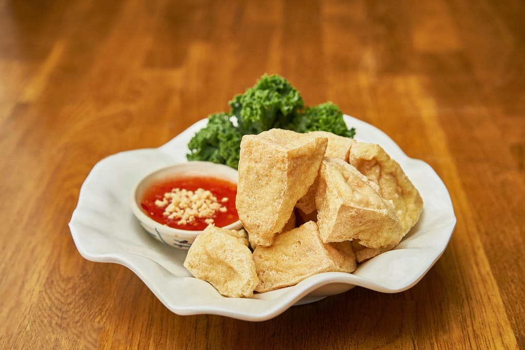 Crispy fried tofu with sweet chili sauce and greens for vegetarian Thai food in NYC